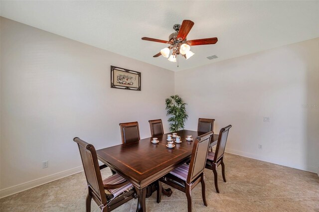 dining space with baseboards, a ceiling fan, and visible vents
