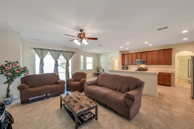 living area featuring visible vents, arched walkways, ceiling fan, and recessed lighting