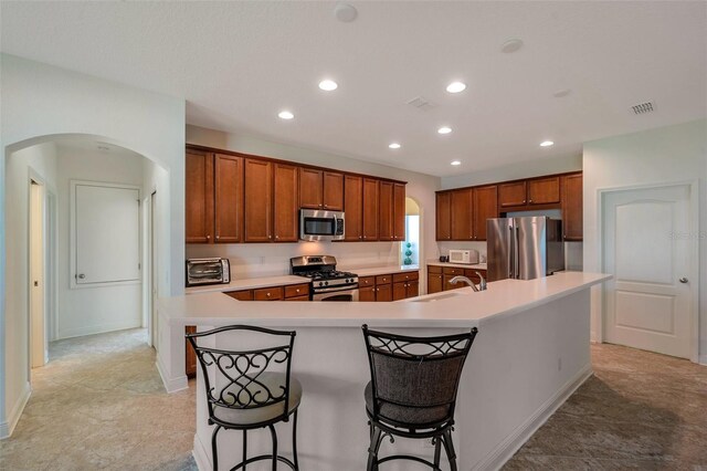 kitchen with visible vents, arched walkways, light countertops, and stainless steel appliances