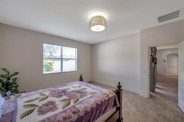 bedroom with visible vents, arched walkways, and baseboards