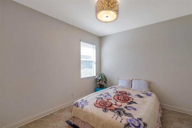bedroom with baseboards and carpet