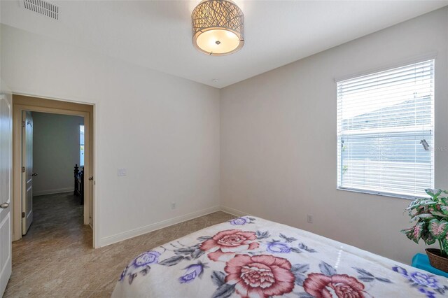 bedroom featuring baseboards, visible vents, multiple windows, and light tile patterned floors