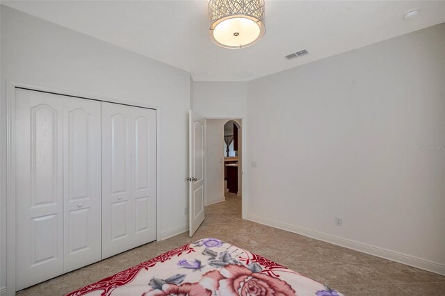 bedroom featuring baseboards, a closet, and visible vents