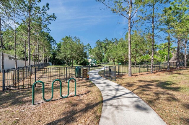 view of property's community featuring fence and playground community