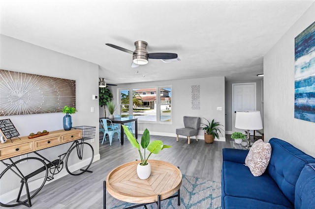 living room featuring baseboards, ceiling fan, wood finished floors, and visible vents