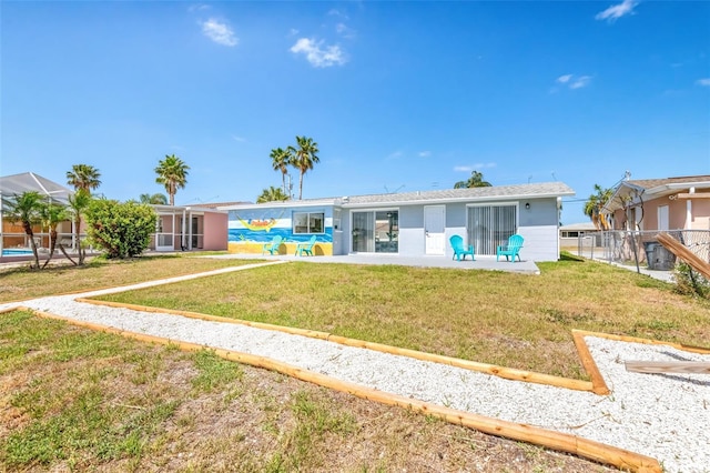 rear view of house with fence, a patio, and a yard