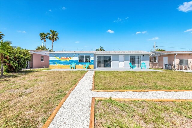 rear view of house with a lawn and a patio