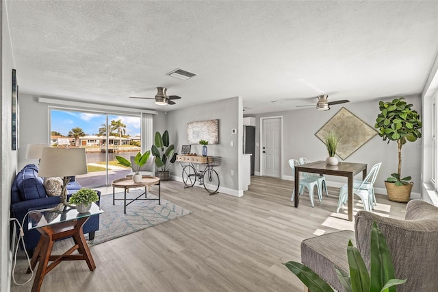 12700 5th Isle, Hudson, FL 34667 - living area with ceiling fan, a textured ceiling, light wood-style floors, and baseboards