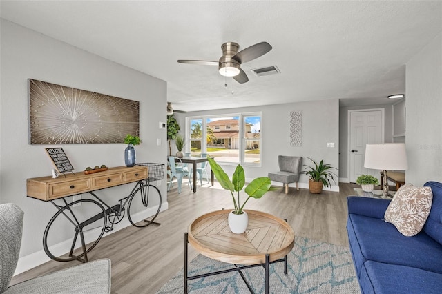 12700 5th Isle, Hudson, FL 34667 - living room featuring baseboards, a ceiling fan, and wood finished floors