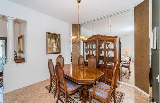 dining room with ornate columns, baseboards, and a notable chandelier