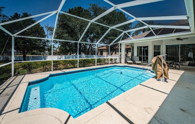 view of pool featuring fence, a fenced in pool, a patio area, a ceiling fan, and glass enclosure