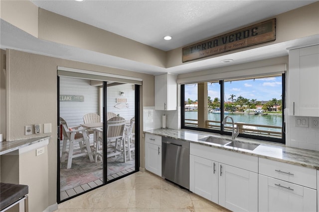350 Pinellas Bayway S Unit 7, Tierra Verde, FL 33715 - kitchen featuring backsplash, stainless steel dishwasher, light stone countertops, a sink, and white cabinetry