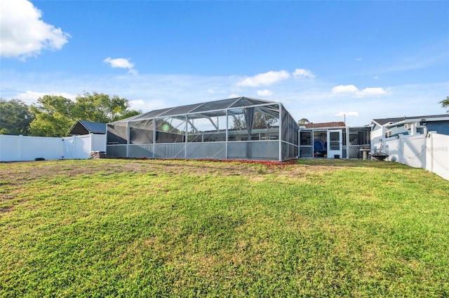 view of yard with glass enclosure and a fenced backyard
