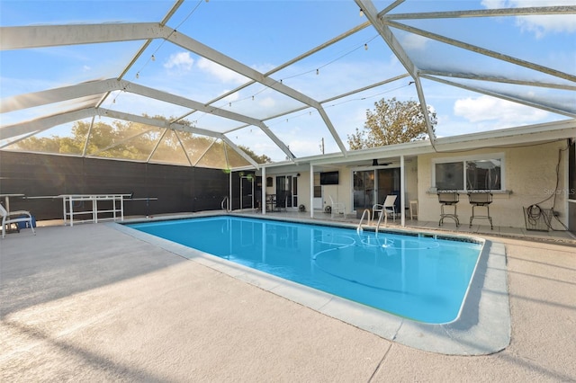outdoor pool with a patio, a lanai, and ceiling fan