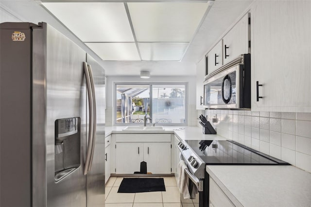 kitchen with light countertops, stainless steel appliances, tasteful backsplash, and a sink