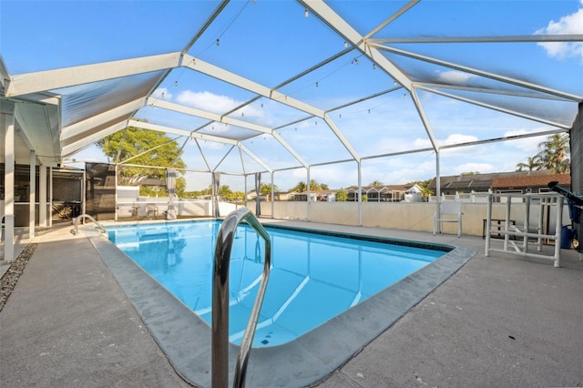 pool featuring glass enclosure and a patio