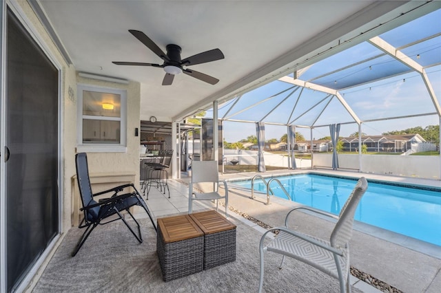 outdoor pool featuring a patio, ceiling fan, and glass enclosure