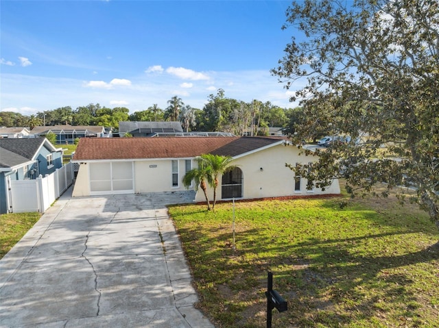 ranch-style home with fence, stucco siding, a front lawn, and driveway