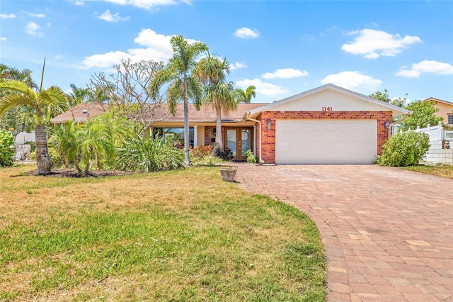 1141 80th Street Ct S, Saint Petersburg, FL 33707 - single story home with a garage, a front lawn, decorative driveway, brick siding, and french doors
