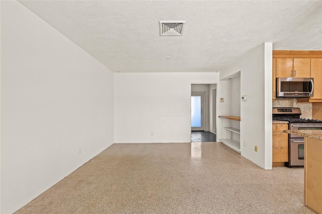 1141 80th Street Ct S, Saint Petersburg, FL 33707 - unfurnished living room with dark aggregate flooring and a textured ceiling
