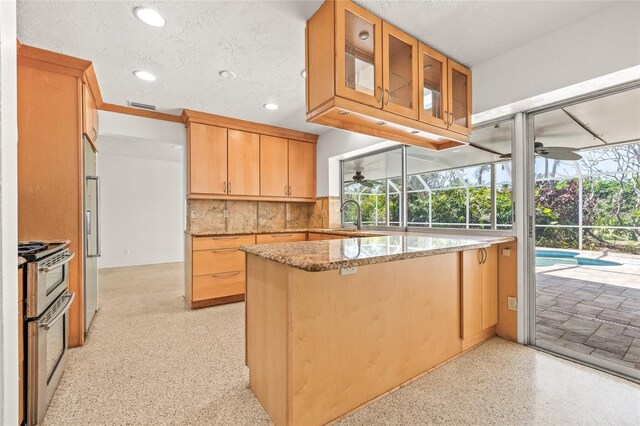 1141 80th Street Ct S, Saint Petersburg, FL 33707 - kitchen with a ceiling fan, range with two ovens, a sink, light stone countertops, and recessed lighting