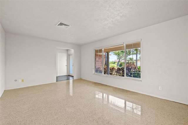 1141 80th Street Ct S, Saint Petersburg, FL 33707 - unfurnished room with speckle patterned floor, a textured ceiling, and baseboards