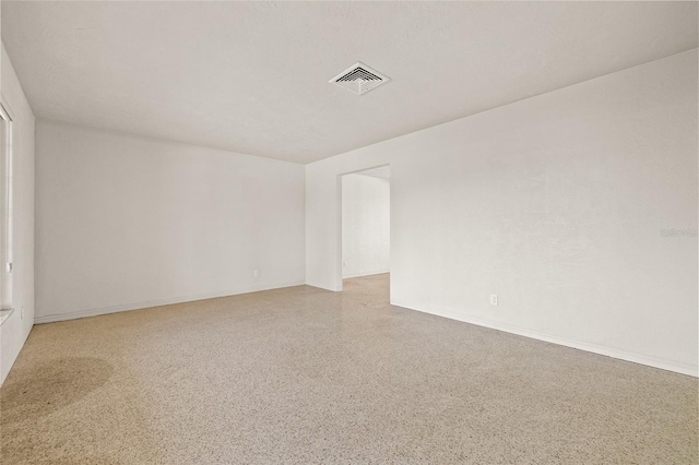 1141 80th Street Ct S, Saint Petersburg, FL 33707 - empty room with dark aggregate flooring and baseboards