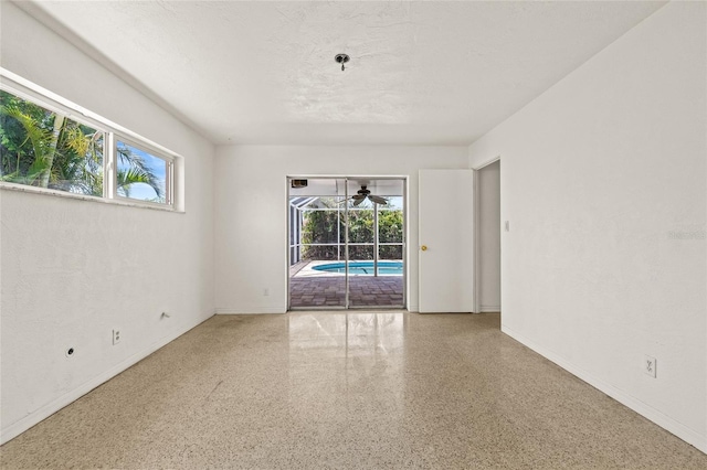 1141 80th Street Ct S, Saint Petersburg, FL 33707 - spare room with speckle patterned floor, plenty of natural light, and baseboards