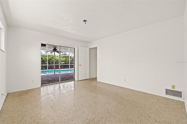 1141 80th Street Ct S, Saint Petersburg, FL 33707 - empty room featuring speckle patterned floor, ceiling fan, and baseboards