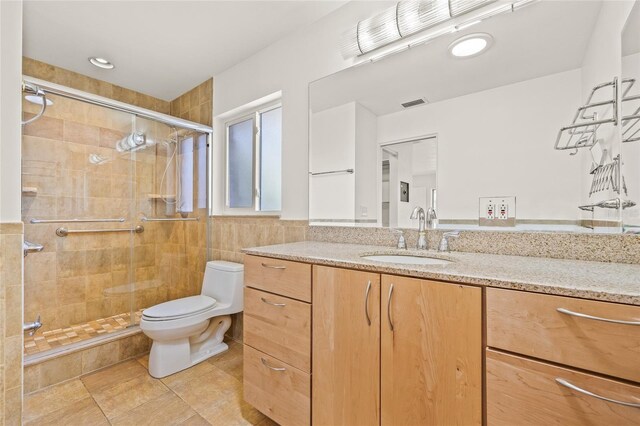 1141 80th Street Ct S, Saint Petersburg, FL 33707 - full bath with toilet, vanity, a shower stall, tile patterned floors, and tile walls