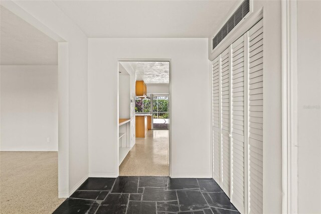 1141 80th Street Ct S, Saint Petersburg, FL 33707 - hall featuring baseboards and dark stone finish floors