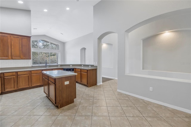 10506 Sky Flower Ct, Land O Lakes, FL 34638 - kitchen featuring light tile patterned floors, brown cabinetry, a kitchen island, and lofted ceiling