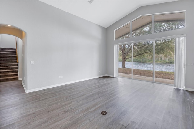 10506 Sky Flower Ct, Land O Lakes, FL 34638 - unfurnished room with baseboards, wood finished floors, stairway, and high vaulted ceiling