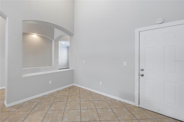 10506 Sky Flower Ct, Land O Lakes, FL 34638 - unfurnished room featuring light tile patterned floors, arched walkways, and baseboards