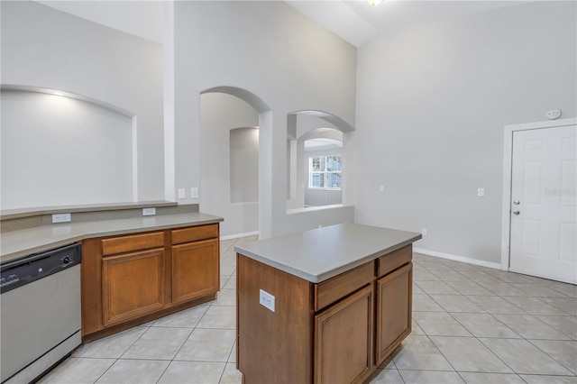 10506 Sky Flower Ct, Land O Lakes, FL 34638 - kitchen with brown cabinets, light tile patterned flooring, a high ceiling, arched walkways, and stainless steel dishwasher