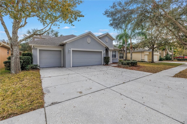 10506 Sky Flower Ct, Land O Lakes, FL 34638 - view of front of property featuring an attached garage, a shingled roof, stucco siding, and driveway