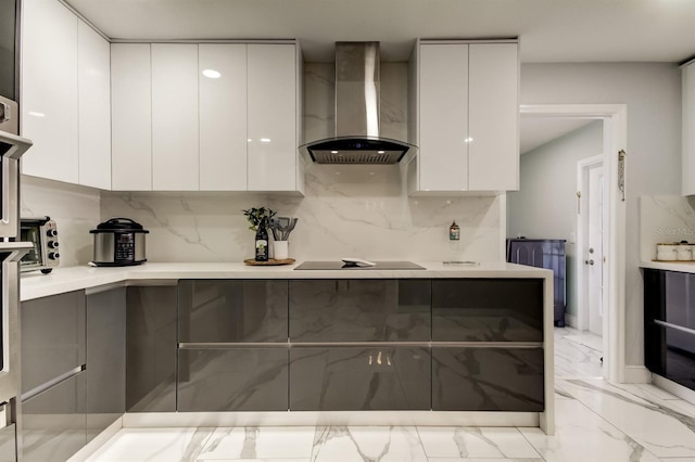kitchen featuring modern cabinets, black electric stovetop, wall chimney exhaust hood, and white cabinets