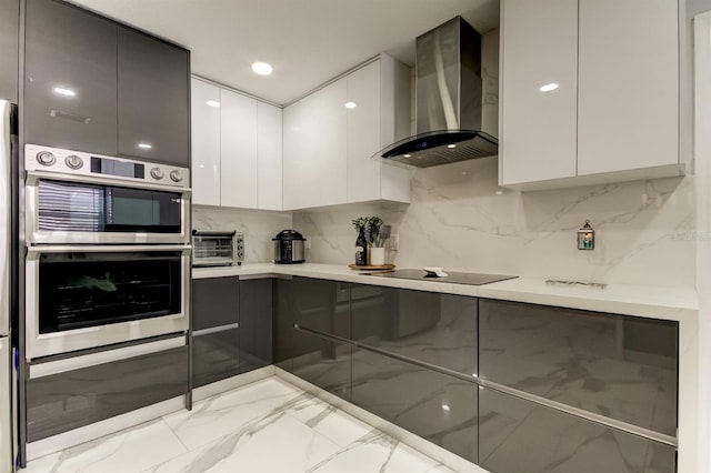 kitchen with white cabinets, marble finish floor, modern cabinets, and wall chimney exhaust hood