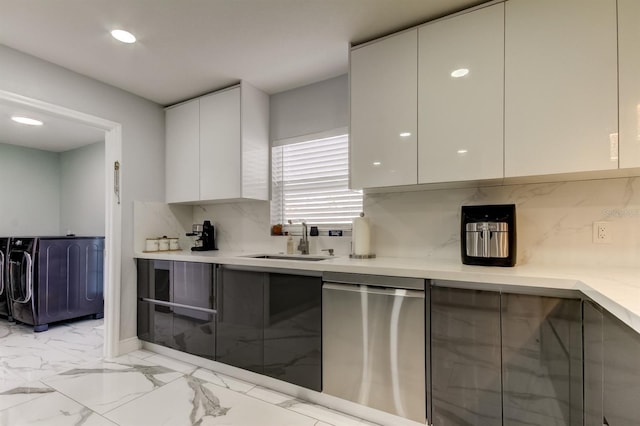 kitchen featuring stainless steel dishwasher, a sink, modern cabinets, and washer and dryer