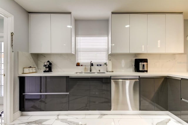 kitchen featuring decorative backsplash, modern cabinets, stainless steel dishwasher, a sink, and marble finish floor