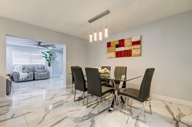 dining area with ceiling fan, baseboards, and marble finish floor