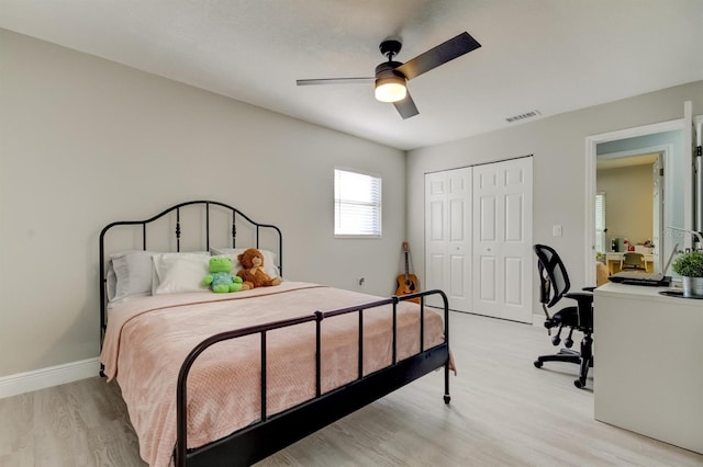 bedroom featuring ceiling fan, visible vents, baseboards, a closet, and light wood-style floors