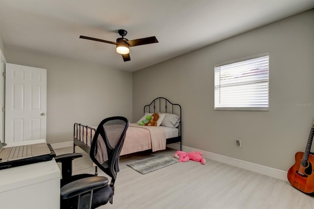 bedroom featuring baseboards, a ceiling fan, and wood finished floors