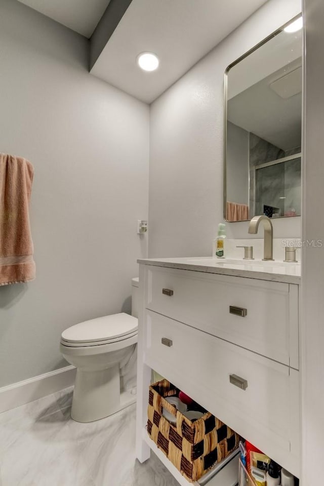 bathroom featuring vanity, marble finish floor, toilet, and a shower stall