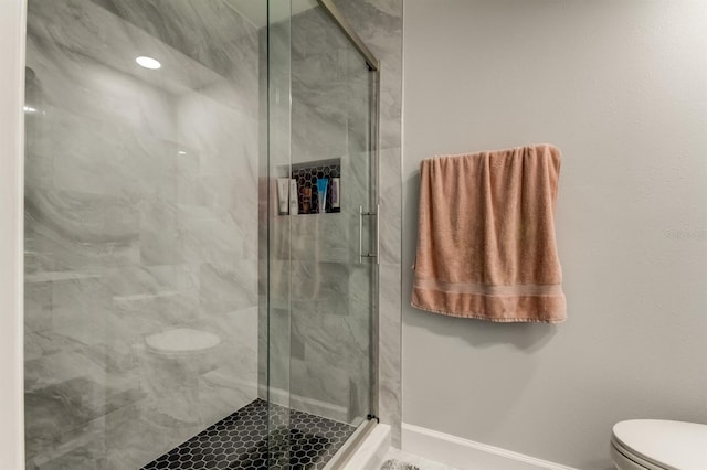 full bath with baseboards, a marble finish shower, and toilet