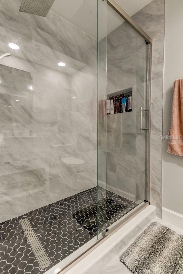 full bathroom featuring a marble finish shower
