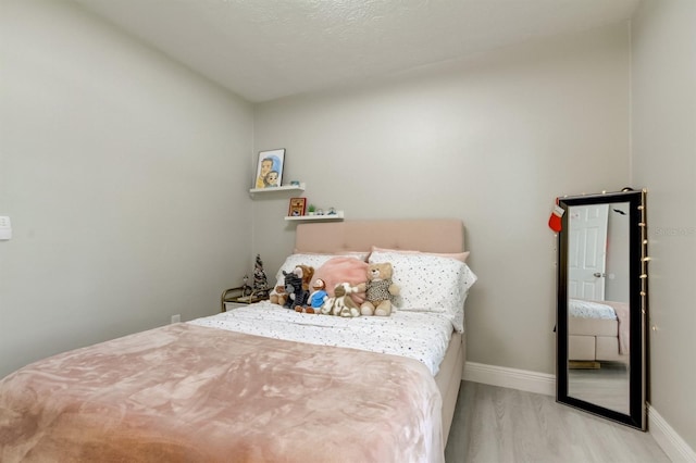 bedroom featuring baseboards and wood finished floors