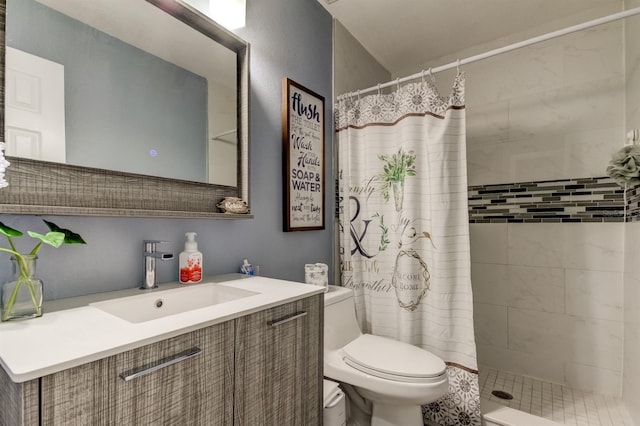 bathroom featuring vanity, toilet, and tiled shower