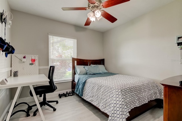 bedroom featuring a ceiling fan, baseboards, and light wood-style flooring