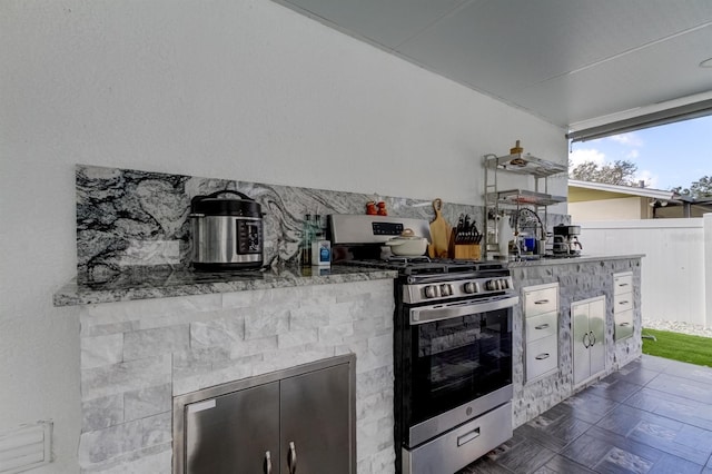 view of patio featuring fence, a sink, and an outdoor kitchen